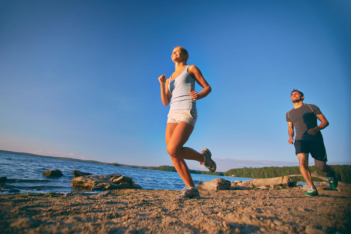 Footing en couple sur la plage au couché de soleil